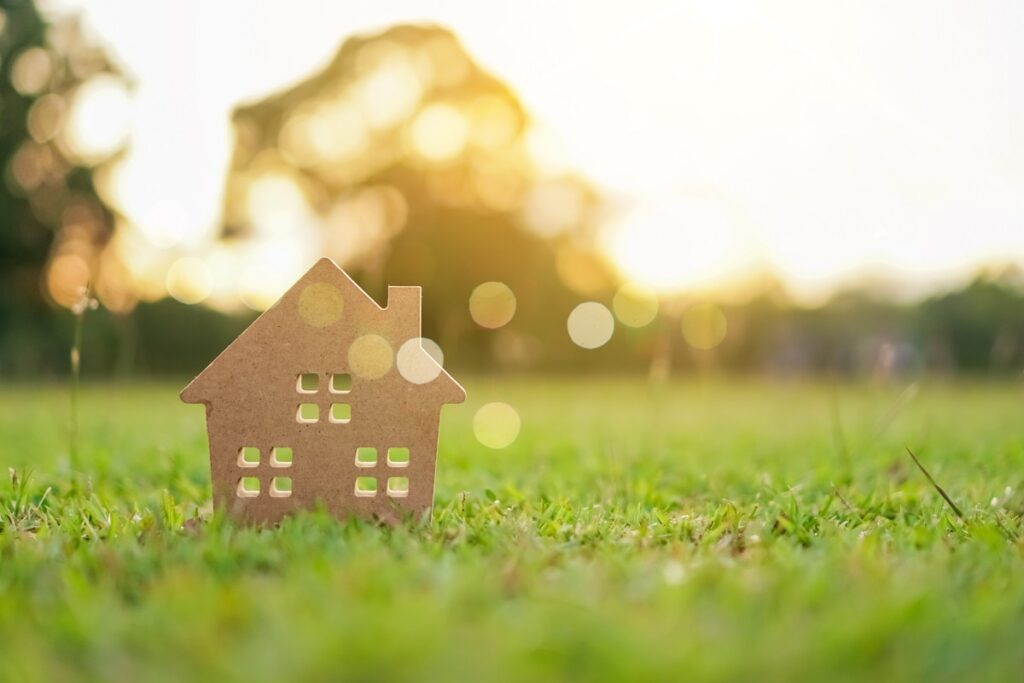 Closed up tiny home model on green grass with sunlight background